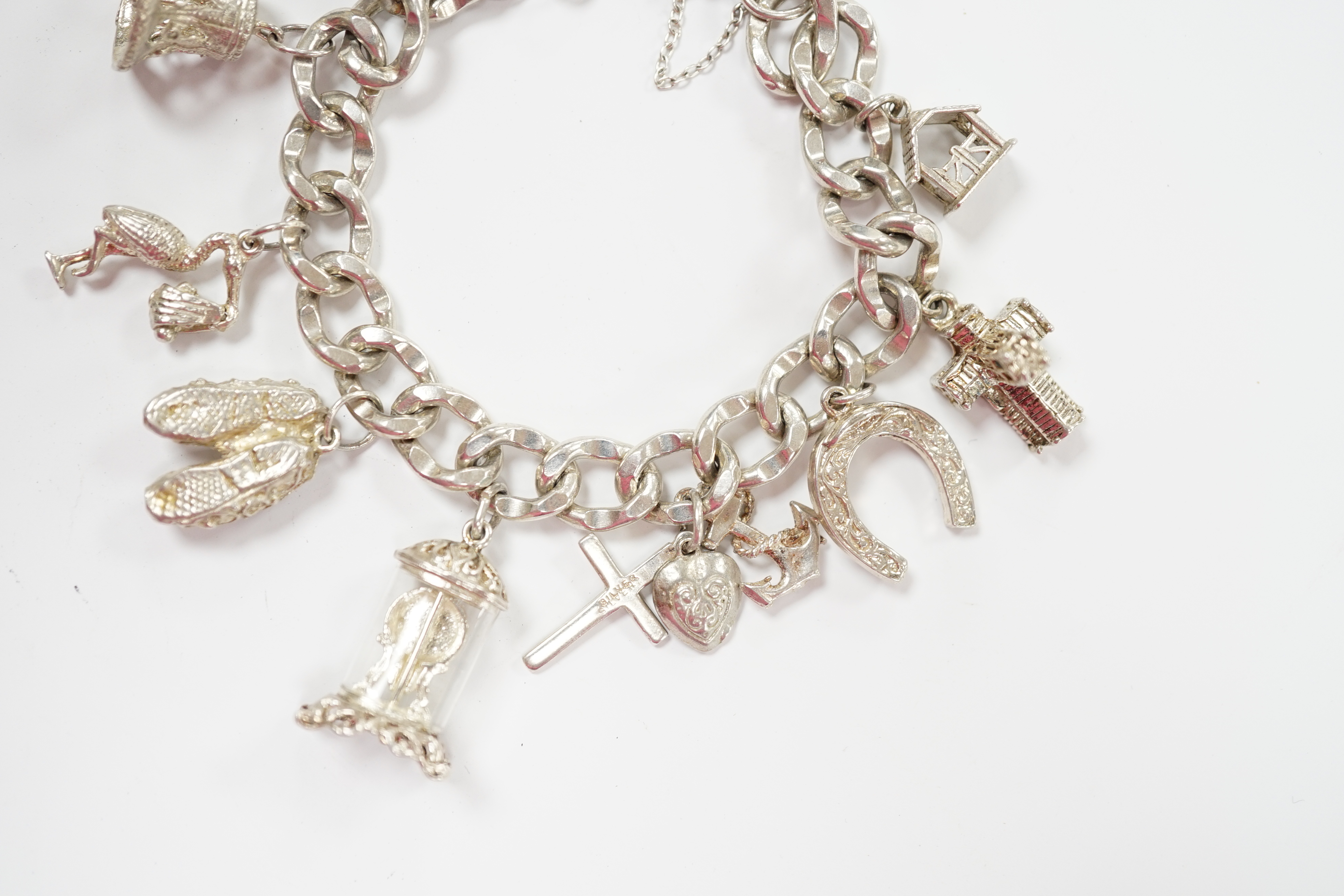 A modern silver charm bracelet, hung with nine assorted charms.